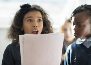young student reads out her writing