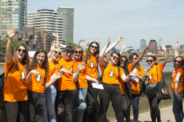 Penguin Random House employees celebrate in orange penguin tshirts