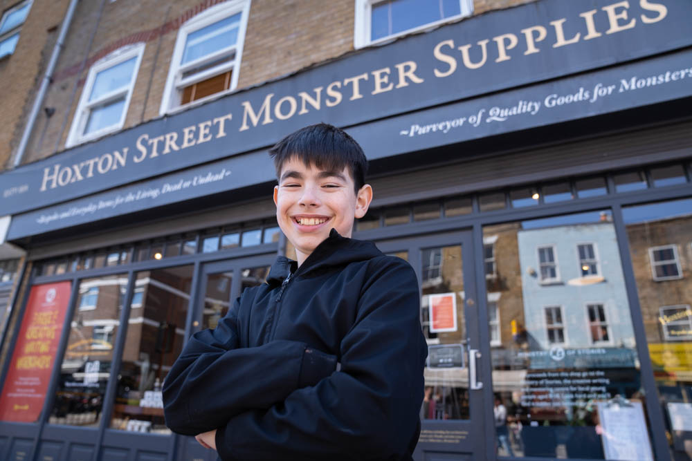 Cian grins broadly in front of the Ministry of Stories building