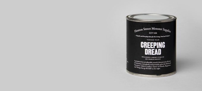 A short, round tin wrapped in black paper which reads 'Creeping Dread'