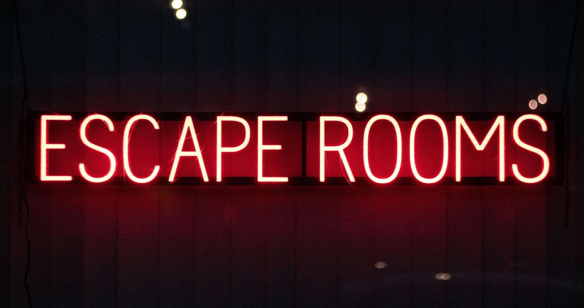 The word Escape Room is lit up in neon lights