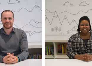 Jamie and Maya sit, smiling at a desk in the back office of the Ministry of Stories.