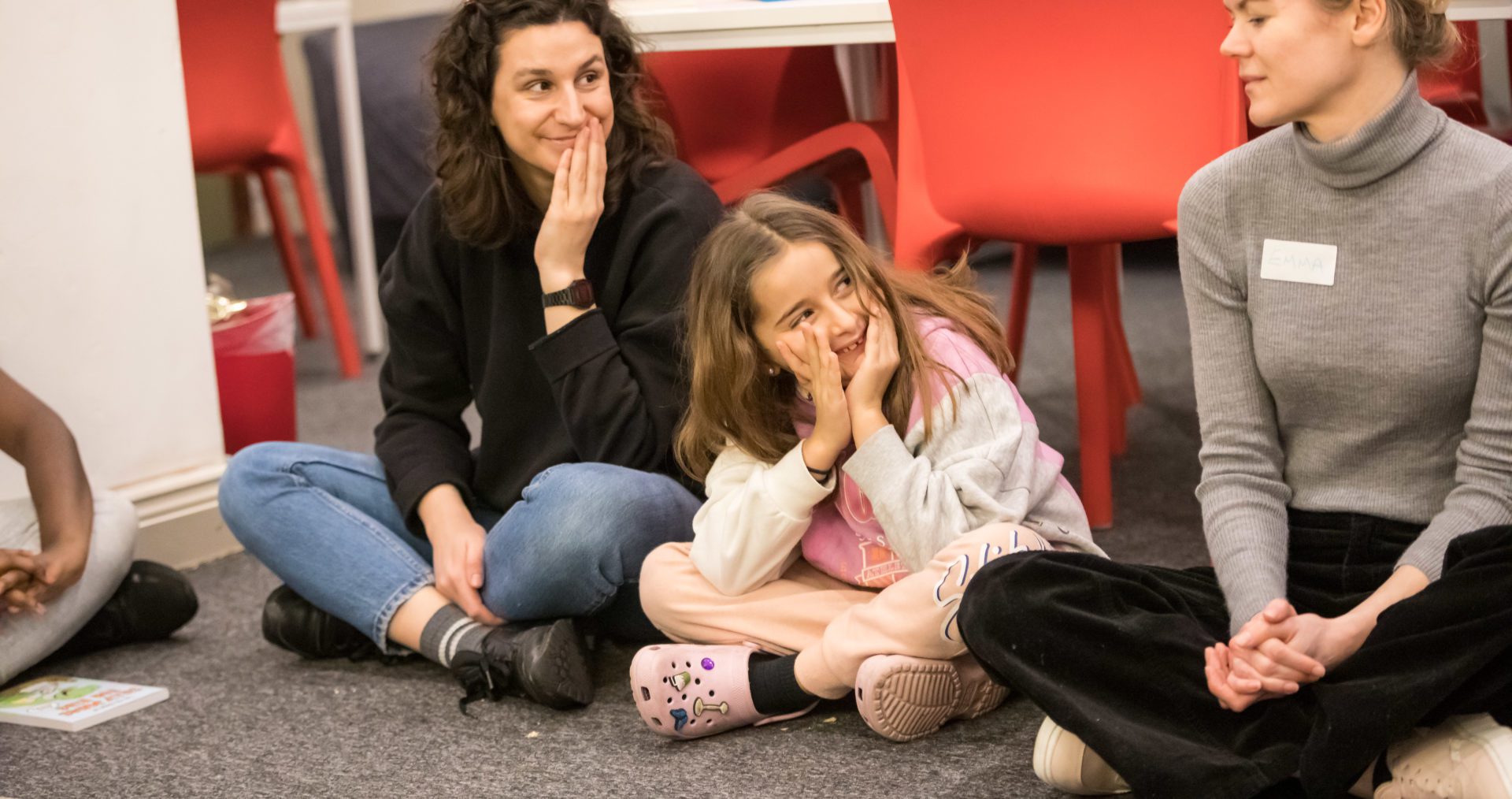 volunteer writing mentor and young person looking to the right with hands over face.