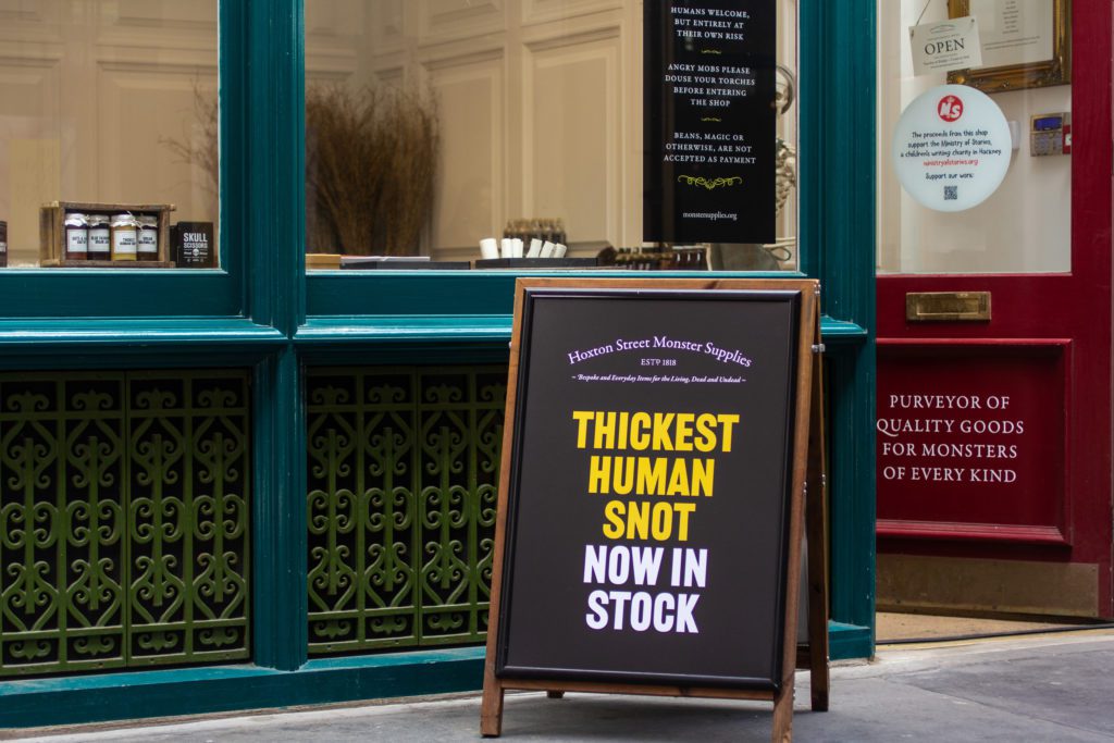 A old style sandwich board outside the store reads 'Thickest Human Snot, now back in stock'