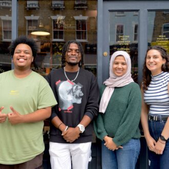Four smiling young adults stand outside the front of Ministry of Stories on Hoxton road.