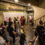 A group of adults and young people congregate outside the Shoreditch Town Hall Basement, about to go in and explore DreamState - an exhibition of young people's writing and ideas.