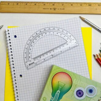 School supplies including pencils, ruler and notebook are spread out over a white table