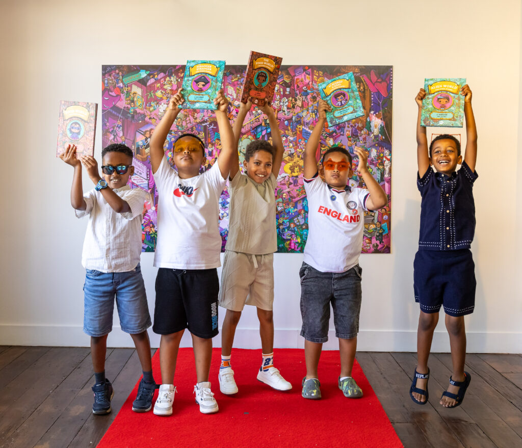 Five young writers hold their published story collections above their head on the red carpet at our celebration event.