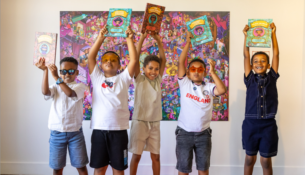 Five young writers hold their published story collections above their head on the red carpet at our celebration event.