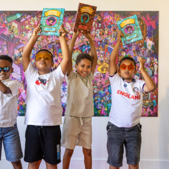 Five young writers hold their published story collections above their head on the red carpet at our celebration event.